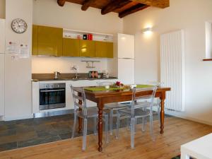 cocina con mesa de madera y sillas en Apartment Cjase dai Fornasirs by Interhome en Raveo