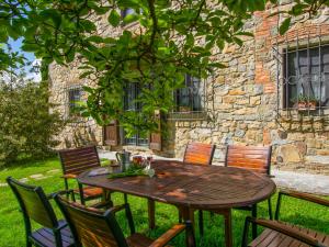 a wooden table and chairs in front of a stone building at Holiday Home Il Casellino-1 by Interhome in Case Malva