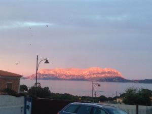 a car parked next to a body of water with mountains at Domus de Diana in Olbia