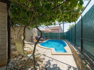 a swimming pool next to a fence with a tree at Holiday Home Villa Lancin - RCA453 by Interhome in Divšići