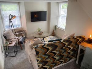 a living room with a couch and a table at The Hive at Poppi-Red in Hawkshead