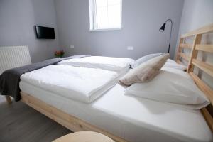 シュクラルスカ・ポレンバにあるWilla Lolobrygidaの白いシーツと窓が備わるベッドルームのベッド2台