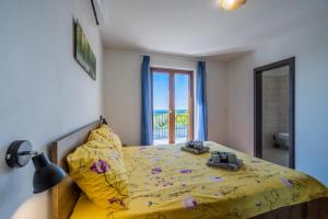 a bedroom with a bed with a yellow comforter at Villa Vanda in Diminići +43 photos