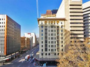 un grand bâtiment blanc dans une ville avec des voitures dans l'établissement Quality Apartments Adelaide Central, à Adélaïde