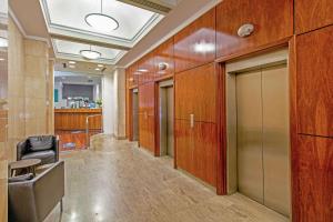 an office hallway with wood paneled walls and doors at Quality Apartments Adelaide Central in Adelaide
