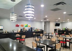 a restaurant with tables and chairs and a bar at Quality Inn Terre Haute University Area in Terre Haute