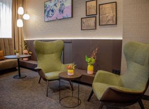 a waiting room with green chairs and a table at Hotel Essener Hof; Sure Hotel Collection by Best Western in Essen