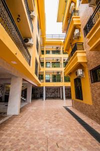 um pátio vazio de um edifício de apartamentos com amarelo em Residence Le Bonheur - Serviced apartment by Douala Airport/Mall em Douala