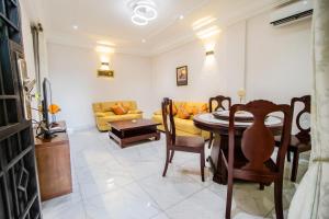 uma sala de estar com uma mesa e cadeiras e um sofá em Residence Le Bonheur - Serviced apartment by Douala Airport/Mall em Douala