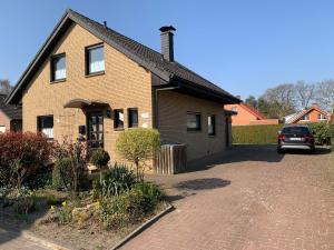 ein Backsteinhaus mit einem Auto in der Einfahrt in der Unterkunft Ferienhaus Wacholderhain in Haselünne