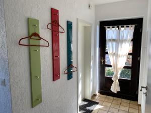 einen Flur mit roten und grünen Türen und einem Fenster in der Unterkunft Ferienhaus Wacholderhain in Haselünne
