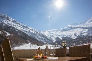 a table with wine glasses and a view of a mountain at Hotel Bristol in Saas-Fee
