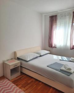 a small bedroom with a bed and a night stand at Apartman Natasha in Trebinje
