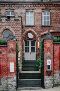 a brick building with a door with a clock on it at La Merveilleuse by Infiniti hôtel in Dinant