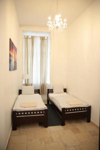 2 łóżka w pokoju z żyrandolem w obiekcie Heart of Vienna - City Apartment w Wiedniu