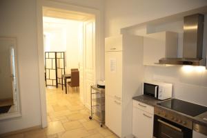 cocina con armarios blancos y microondas en Heart of Vienna - City Apartment, en Viena