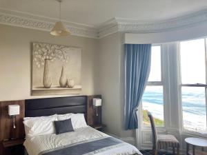 a bedroom with a bed and a large window at The Selomar in Scarborough