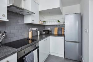 uma cozinha com armários brancos e um frigorífico branco em Halifax Gorgeous New Home - 3 bedrooms em Halifax