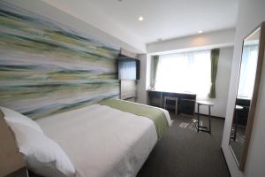 Postel nebo postele na pokoji v ubytování Kuretake Inn Premium Numazu Kitaguchi Ekimae