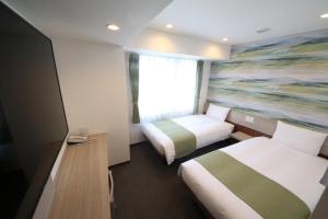 Postel nebo postele na pokoji v ubytování Kuretake Inn Premium Numazu Kitaguchi Ekimae