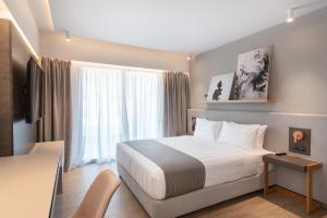 a hotel room with a bed and a window at The Residences Kalamata in Kalamata