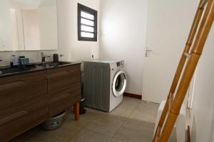 a kitchen with a washing machine and a sink at Gîte TI KAZ MORINGA, Entre Volcan, Cilaos et Sud sauvage in Saint-Louis