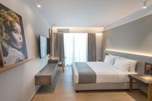 a hotel room with a bed and a large window at The Residences Kalamata in Kalamata