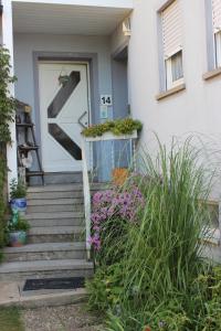 una puerta delantera de una casa con flores en las escaleras en Ferienwohnung Schwalbennest, en Sommerach