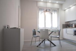ein Esszimmer mit einem Tisch und Stühlen in einer Küche in der Unterkunft BnButler - Aquileia - Bilocale a Due Passi da Navigli e Museo Scienza in Mailand