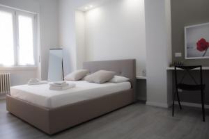 ein weißes Schlafzimmer mit einem großen Bett mit weißer Bettwäsche in der Unterkunft BnButler - Aquileia - Bilocale a Due Passi da Navigli e Museo Scienza in Mailand