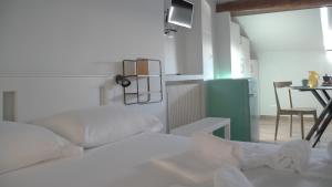 a white bed in a room with a table and a kitchen at Via Garibaldi 75 - Attic sea view in Camogli