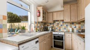 a kitchen with wooden cabinets and a large window at Lake Retreat in Poole