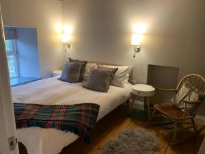 a bedroom with a bed with a chair and a table at Min-Y-Fford sleeps 6 plus pet in Newport Pembrokeshire