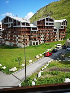 uma vista de um edifício com carros estacionados num parque de estacionamento em Borsat - Beau Studio 4pax sur les pistes, avec balcon em Tignes