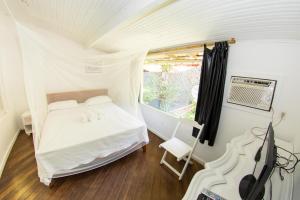 a small bedroom with a bed and a window at Casa Grande Flats in Abraão