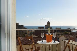 einen Tisch mit einer Flasche Wein und zwei Gläser auf dem Balkon in der Unterkunft Antica Dimora in Centro in Salerno