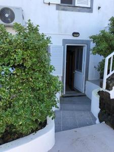 un edificio blanco con una puerta y algunos arbustos en Alojamentos Flores Island, en Faja Grande