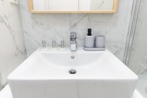 un lavandino bianco in bagno con doccia di NorthApartments a Bucarest