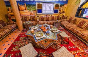 a living room with couches and a table with dishes on it at Riad Sephora in Tinerhir