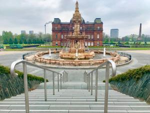a water fountain in front of a building at Glasgow Green Park Home in Glasgow