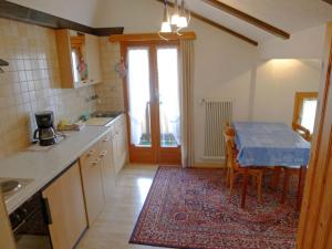 uma cozinha com uma mesa e um balcão azul em Heiderösli 1st Floor and Attic Apartment em Grächen
