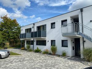 a white building with a car parked in the driveway at Rainer Appartements in Besigheim