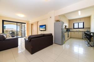 a kitchen and living room with two couches and a refrigerator at Blue Serenity Complex in Larnaka