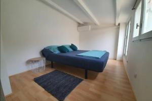 una camera da letto con un letto blu in una stanza di La Montille a Arles