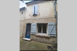 un edificio con persiane blu e finestra di La Montille a Arles