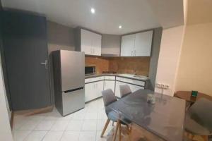 una cucina con tavolo e frigorifero di La Montille a Arles