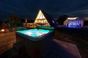 a jacuzzi tub in a yard at night at Woodparadise in Nagyrada