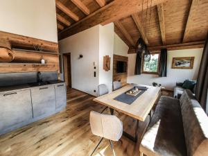 a kitchen and living room with a wooden ceiling at Zeitfrei Chalet Apartments in Fieberbrunn