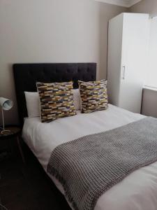 a bedroom with a large bed with pillows on it at Ons Strandhuisie Mh18 in Pearly Beach in Pearly Beach