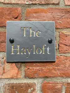 a sign on a brick wall that reads the laughter at Field Farm Holiday Cottages and Glamping in Anderby